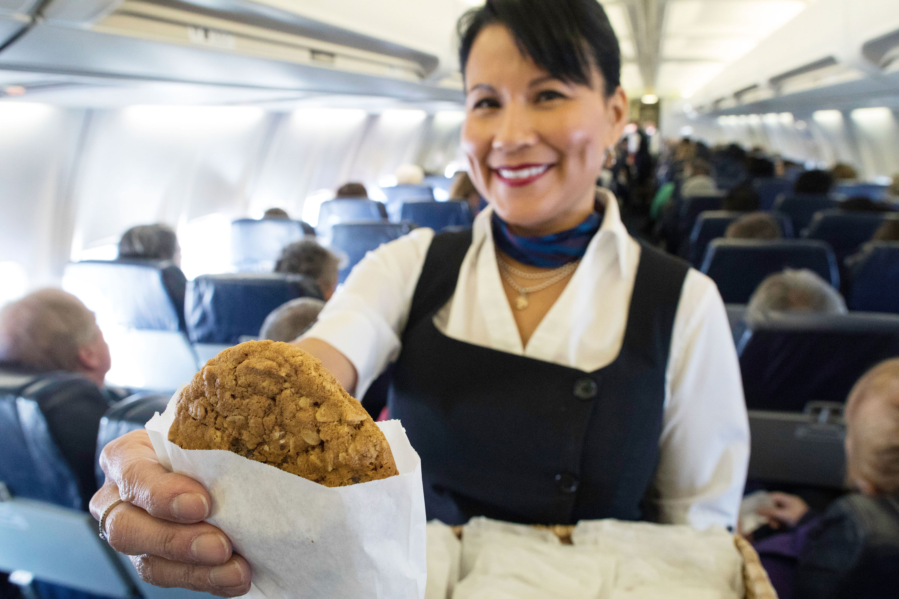Flight attendant holding a cookie