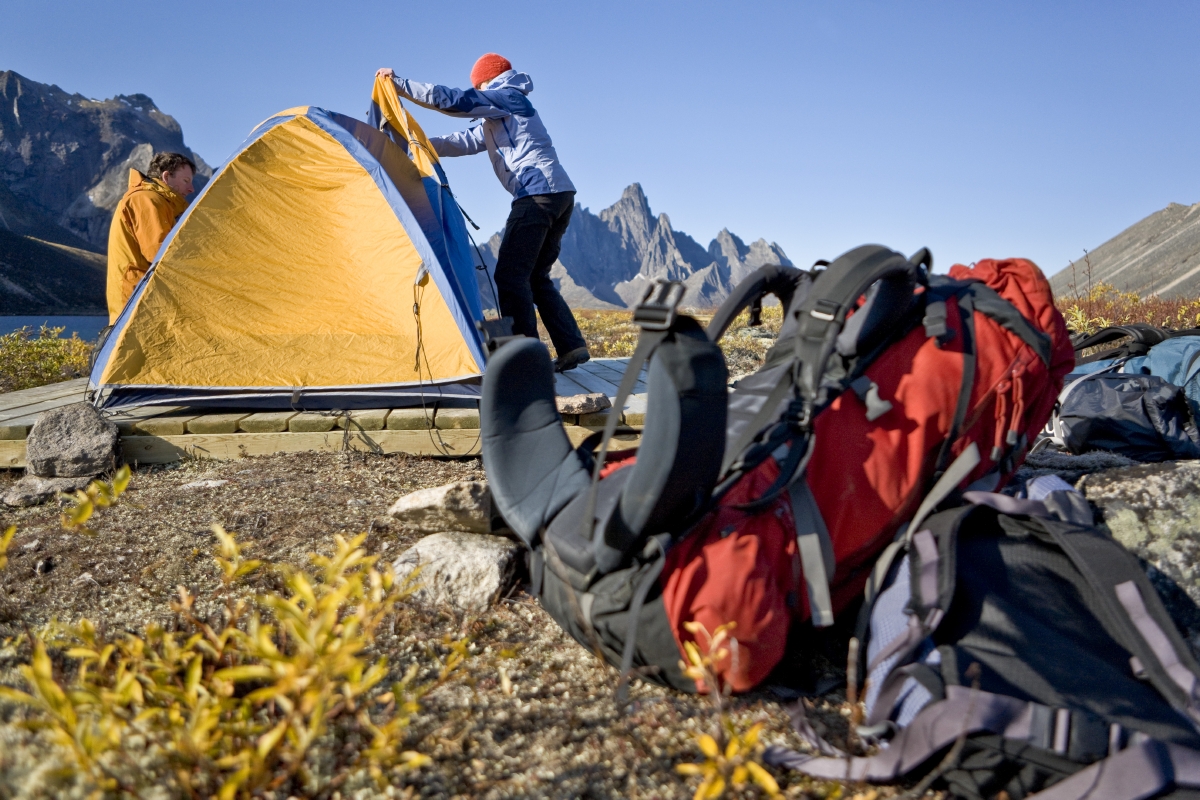 Two backpackers setting up a tent