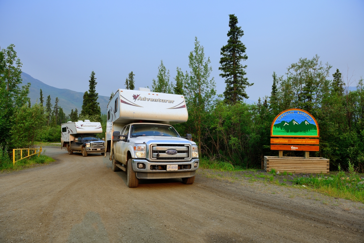 Two camper trucks driving out of campground