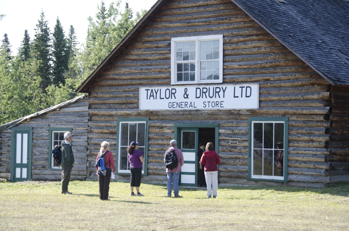 Group of people in front of a historic building at Fort Selkirk